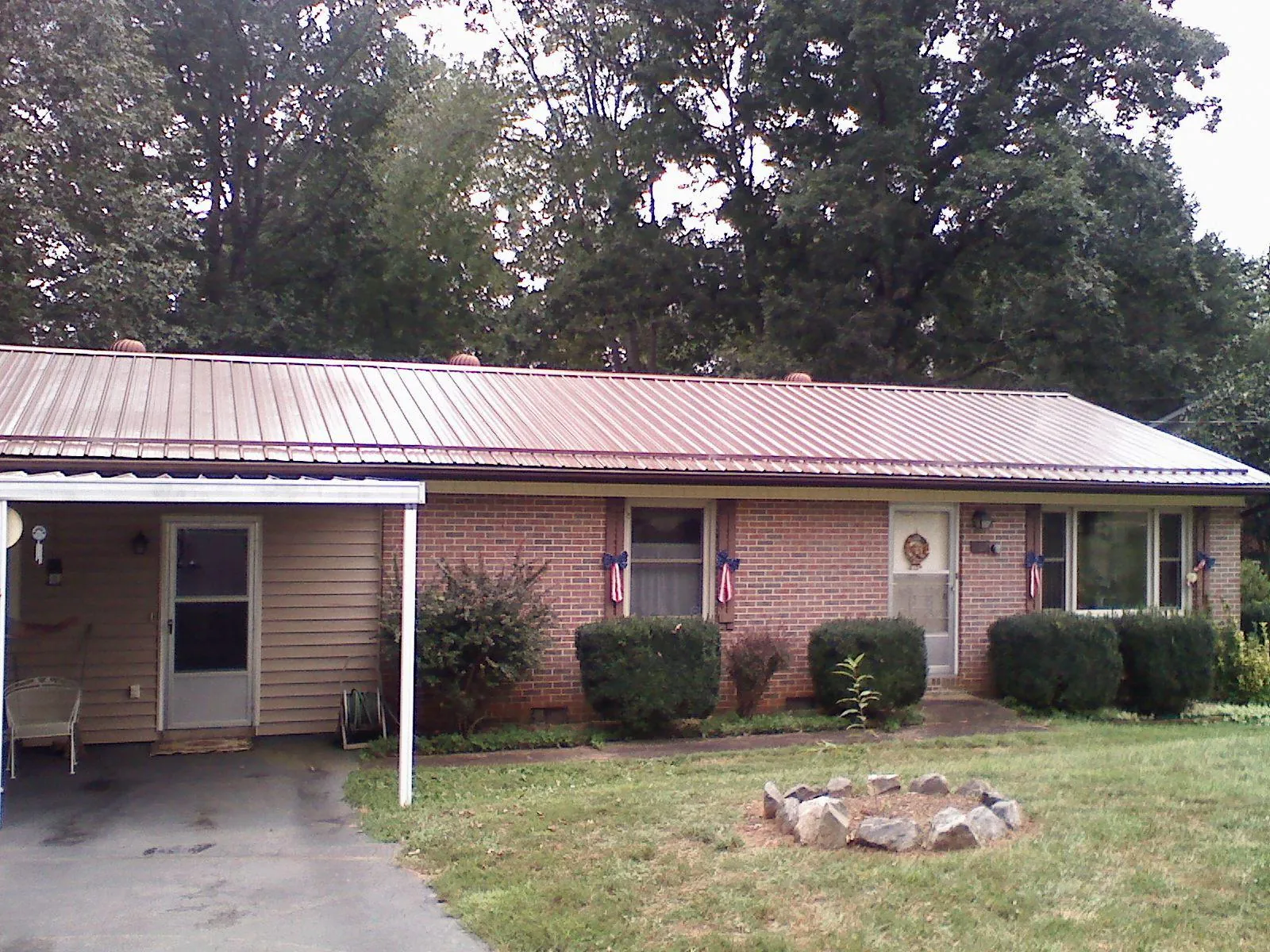 Bronze metal roof and carport on a brick ranch home — Roof Repair work by our crew in Caneyville